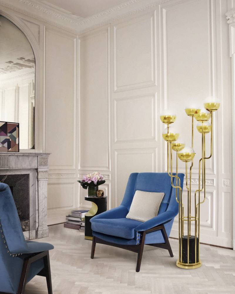 Living room by Brabbu with blue armchairs and golden floor lamp