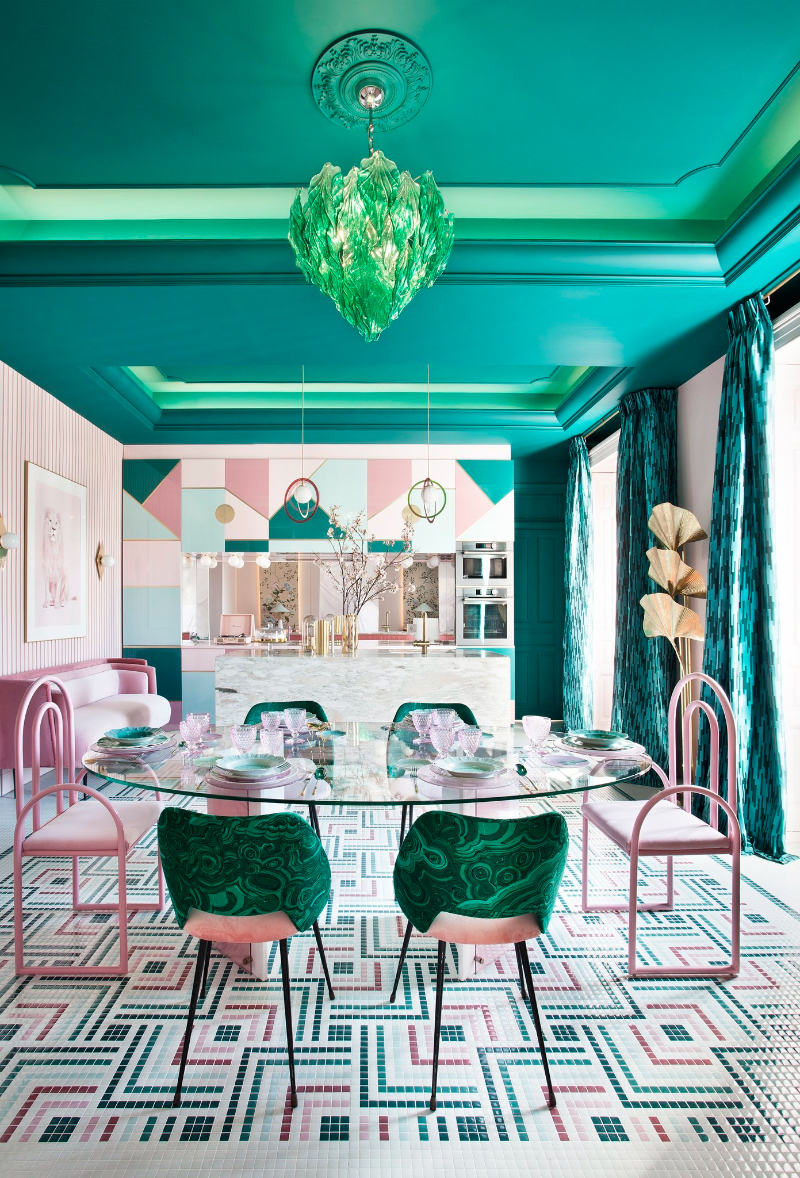 kitchen and dining room by Patricia Bustos Studio with colorful details, golden floor lamp and pink and green chairs